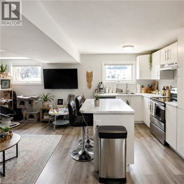 London apartment for rent - A modern kitchen with a white island and black bar stools.