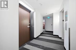 Ottawa condo for rent - A hallway with a door on the left and a sign on the wall.