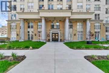 Hamilton condo for rent - A building with a large front entrance and a walkway leading to it.