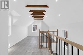Ottawa apartment for rent - A spacious room with a wooden staircase and white walls.