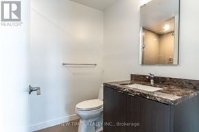 Toronto (Waterfront Communities) condo for rent - A bathroom with a toilet, sink, and mirror.