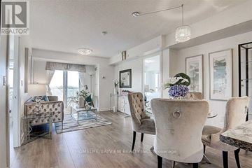 Toronto (Eglinton East) condo for rent - A well-lit living room with a grey sofa and a glass coffee table.