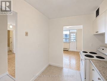 Toronto (Eglinton East) condo for rent - A white kitchen with a stove top oven and a window.
