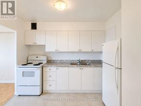 Toronto (Eglinton East) condo for rent - A white kitchen with a stove, sink, and cabinets.
