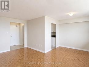 Toronto (Eglinton East) condo for rent - A room with wooden flooring and white walls, with a doorway leading to another room.