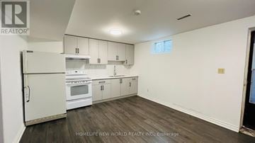 Richmond Hill (North Richvale) apartment for rent - A kitchen with white appliances and cabinets in a room with wood flooring.