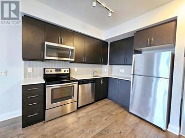 Toronto (Islington-City Centre West) condo for rent - A kitchen with black cabinets and stainless steel appliances.