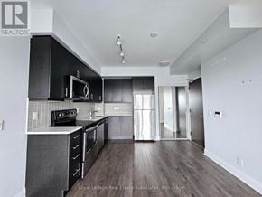Toronto (Islington-City Centre West) condo for rent - A modern kitchen with dark wood floors and white walls.