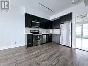 Toronto (Islington-City Centre West) condo for rent - A modern kitchen with black cabinets and stainless steel appliances.
