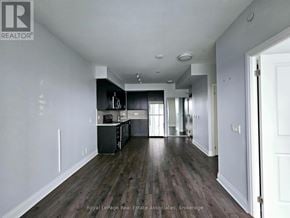 Toronto (Islington-City Centre West) condo for rent - A spacious kitchen with dark wood floors and white walls.