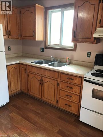 Waterloo apartment for rent - A kitchen with wooden cabinets and a white fridge.