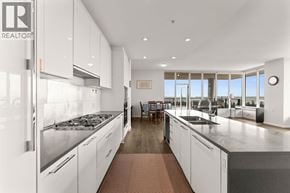 Vancouver apartment for rent - A modern kitchen with white cabinets and stainless steel appliances.
