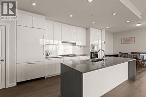 Vancouver apartment for rent - A modern kitchen with white cabinets and a large island.