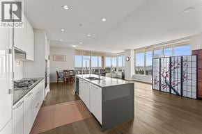 Vancouver apartment for rent - A modern kitchen with white cabinets and a large island.