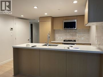 Vancouver apartment for rent - A modern kitchen with a large island and a microwave above it.