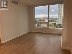 Vancouver apartment for rent - A room with a large window overlooking a cityscape.
