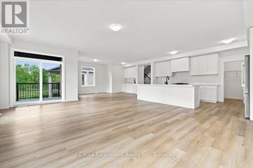 Hamilton (Waterdown) townhouse for rent - A spacious kitchen with white cabinets and a wooden floor.