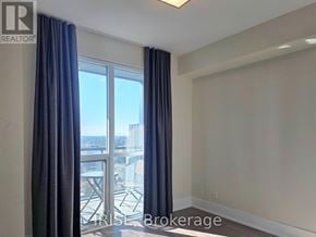 Toronto (Waterfront Communities) condo for rent - A room with a view of a cityscape through a large window.