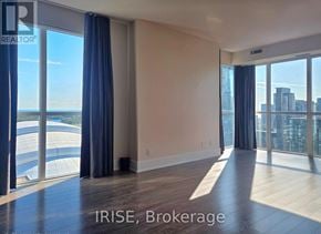 Toronto (Waterfront Communities) condo for rent - A spacious room with large windows overlooking a cityscape.