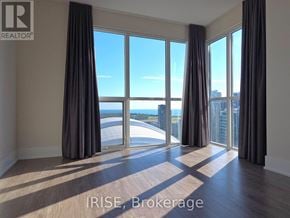 Toronto (Waterfront Communities) condo for rent - A room with large windows overlooking a body of water.