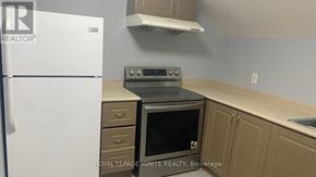 Whitchurch-Stouffville (Stouffville) apartment for rent - A kitchen with a white fridge, a stove and a microwave.