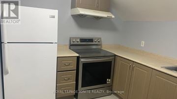 Whitchurch-Stouffville (Stouffville) apartment for rent - A kitchen with a white fridge, a stove and a microwave.
