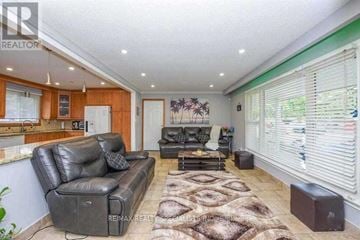 Brampton (Central Park) apartment for rent - A living room with a black leather couch and a brown rug.