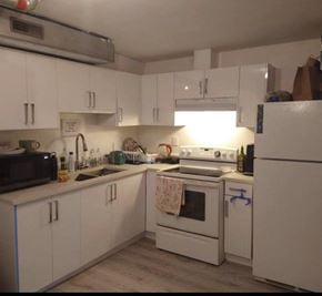 Surrey apartment for rent - A kitchen with white cabinets and a white oven.