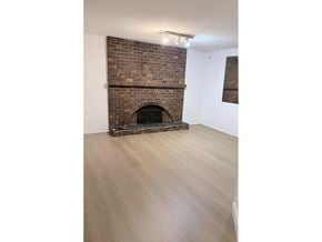 Surrey apartment for rent - A brick fireplace in a room with wooden flooring.