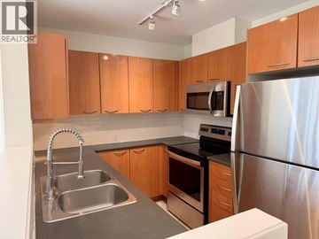 Burnaby apartment for rent - A kitchen with wooden cabinets and stainless steel appliances.