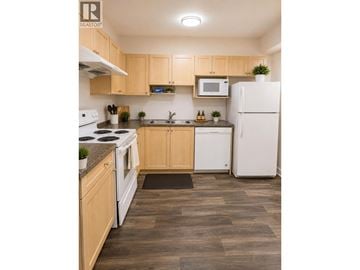 Coquitlam apartment for rent - A kitchen with wooden cabinets and a white fridge.