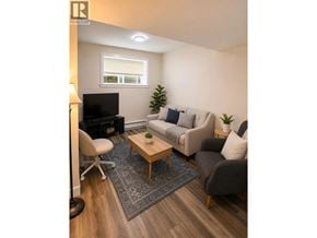 Coquitlam apartment for rent - A living room with a couch, chair, and television.