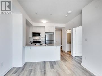 Hamilton (Waterdown) condo for rent - A modern kitchen with white cabinets and a wooden floor.