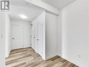 Hamilton (Waterdown) condo for rent - A white room with a wooden floor and a door on the left.