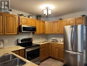 Perth multi-family for rent - A kitchen with wooden cabinets and stainless steel appliances.