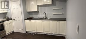 Milton (Ha Harrison) apartment for rent - A kitchen with white cabinets and a black countertop.