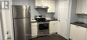 Milton (Ha Harrison) apartment for rent - A kitchen with white cabinets and a stainless steel refrigerator.