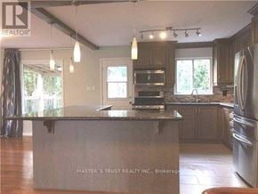 Richmond Hill (North Richvale) apartment for rent - A kitchen with a large island in the middle and a refrigerator on the right side.