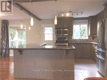 Richmond Hill (North Richvale) apartment for rent - A kitchen with a large island in the middle and a refrigerator on the right side.