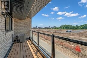 Oakville (Jm Joshua Meadows) townhouse for rent - A balcony with a glass railing overlooking a construction site.