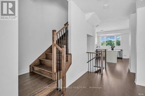 Oakville (Jm Joshua Meadows) townhouse for rent - A wooden staircase with a metal railing leads to a bright room with a window.