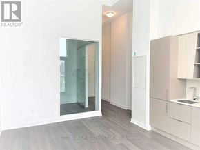 Mississauga (City Centre) condo for rent - A modern kitchen with a glass door and white cabinets.