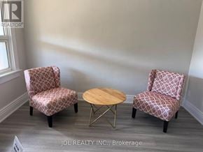 Niagara Falls (Dorchester) apartment for rent - Two chairs and a table are in a room with a sign that says JDL REALTY INC., Brokerage.