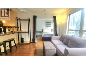 Vancouver apartment for rent - A living room with a grey couch and a black and white checkered bar.