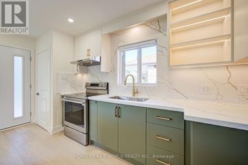 Toronto (Dorset Park) apartment for rent - A kitchen with green cabinets and a marble countertop.