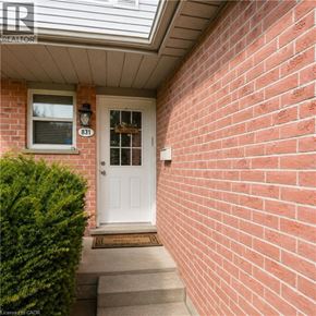 London apartment for rent - A red brick wall with a white door and window.