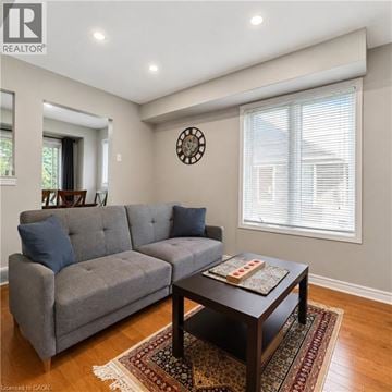 London apartment for rent - A grey couch sits in a living room with a clock on the wall.