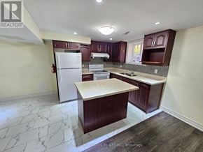 Toronto (Rouge) apartment for rent - A kitchen with a white fridge and wooden cabinets.