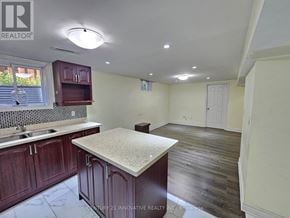 Toronto (Rouge) apartment for rent - A kitchen with dark wood cabinets and a granite countertop.