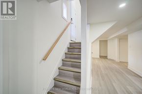 Toronto (Dorset Park) apartment for rent - A staircase with a wooden handrail and steps leading to a doorway.